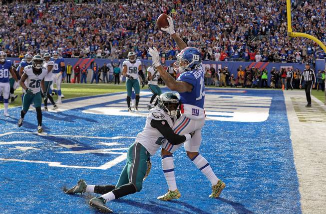 New York Giants wide receiver Odell Beckham (13) gets both feet down in the end zone for a touchdown after catching a pass as Philadelphia Eagles cornerback Leodis McKelvin (21) makes the hit during the second quarter of an NFL football game, Sunday, Nov. 6, 2016, in East Rutherford, N.J. (AP Photo/Bill Kostroun)