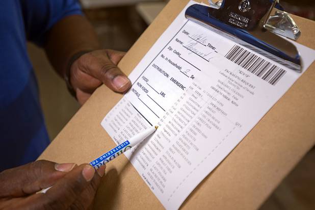 Derrick Felder, facilities and nutrition manger, looks over Margaret Coleman's food order at Lutheran Social Services of Nevada (LSSN) Monday, Nov. 7, 2016. LSSN has installed DigiMart software, an online food pantry system.