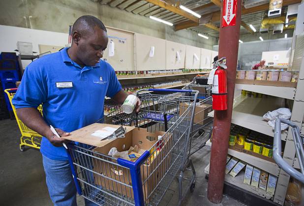 Derrick Felder, facilities and nutrition manger, checks Margaret Coleman's food order at Lutheran Social Services of Nevada (LSSN) Monday, Nov. 7, 2016. LSSN has installed DigiMart software, an online food pantry system.