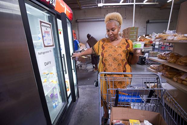 Margaret Coleman chooses an item from a dairy cooler at the Lutheran Social Services of Nevada (LSSN) food pantry Monday, Nov. 7, 2016. LSSN has installed DigiMart software, an online food pantry system. Order "pickers'" fulfill most of the order, then the client just selects from meat, dairy and vegetables aisles.