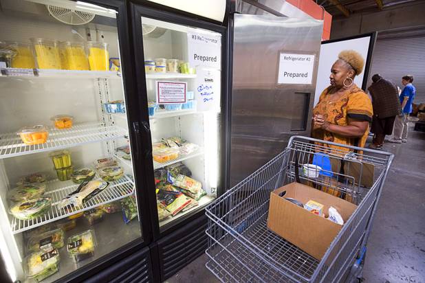 Margaret Coleman chooses an item from cooler the at Lutheran Social Services of Nevada (LSSN) food pantry Monday, Nov. 7, 2016. LSSN has installed DigiMart software, an online food pantry system. Order "pickers'" fulfill most of the order, then the client just selects from meat, dairy and vegetables aisles.