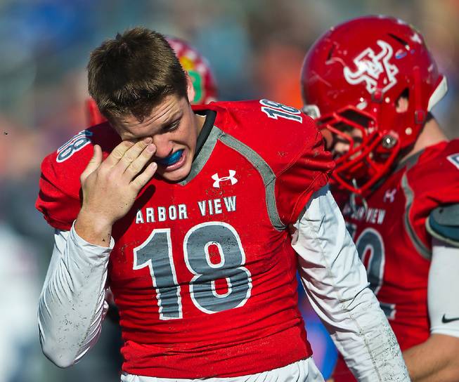 Arbor View's QB Hayden Bollinger (18) wipes his eye after another hard tackle by Bishop Gorman defenders during their state semi-final game at Arbor View on Saturday, Nov. 26, 2016.