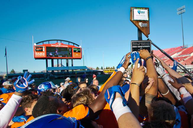 Bishop Gorman players celebrate another trophy this time over Liberty following their high school football state championship game at Sam Boyd Stadium on Saturday, Dec. 3, 2016.