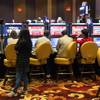 Gamblers play poker slot machine games during Lucky Dragons grand opening celebration, Saturday, Dec. 3, 2016.