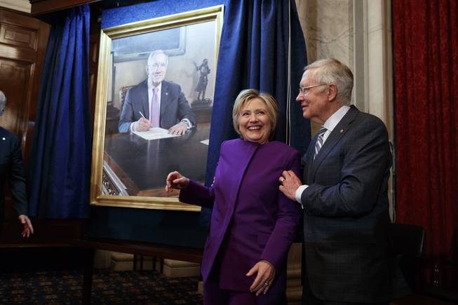 Former Secretary of State Hillary Clinton smiles with Reid during a ceremony to unveil a portrait of him on Capitol Hill on Dec. 8, 2016.