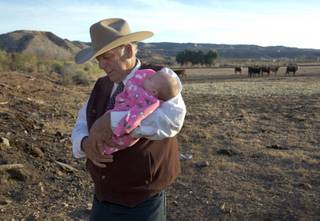 Rancher Cliven Bundy carries his granddaughter Adahlen Bundy at his ranch near Bunkerville, Nev. Wednesday, Jan. 27, 2016. Bundy reacted to the arrest of his sons, Ammon and Ryan Bundy, and the death of his friend Robert 