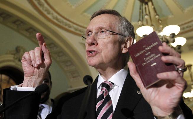 Senate Majority Leader Harry Reid holds a copy of the Constitution and Declaration of Independence during a news conference on Capitol Hill in 2010.