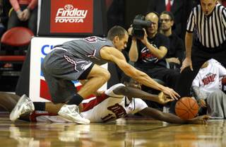 UNLV's Cheickna Dembele (11) and Austin Weiher (15) dive for a loose ball as the Runnin' Rebels take on the Southern Illinois Salukis at the Thomas & Mack Center Monday, Dec. 19, 2016.