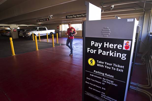 A man and his son walk by parking payment machines at  the New York-New York parking garage Tuesday, Dec. 20, 2016.