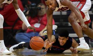 UNLV forward Cheickna Dembele (11) and Boise State guard Chandler Hutchison (15) scramble for a loose ball on the court during their game at the Thomas & Mack Center on Wednesday, Jan. 4, 2017.