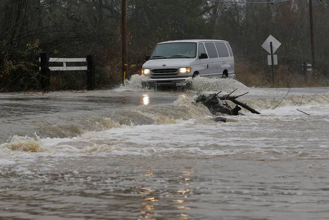 A van drives through flood water Saturday, Jan. 7, 2017, on Green Valley Road in Graton, Calif. On the California coast, weather forecasters anticipate a storm surge from the Pacific called an atmospheric river to dump several inches of rain from Sonoma to Monterey counties, and up to a foot in isolated places in the Santa Cruz mountains.