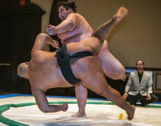 Sumo wrestler Byambajav Ulambayar is tossed from the ring by Ryuichi Yamamoto in a demonstration match during Otakon Vegas at Planet Hollywood on Saturday, Jan. 14, 2017.