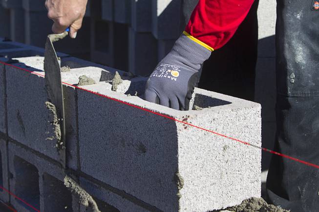 A mason lays down a cinderblock in the "Fastest Trowel on the Block" competition during the World of Concrete convention at the Las Vegas Convention Center Wednesday, Jan. 18, 2017. The event is similar to the annual Bricklayer 500 but with cinderblocks.