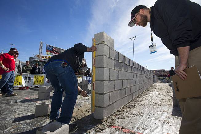 Judges check a wall in the "Fastest Trowel on the Block" competition during the World of Concrete convention at the Las Vegas Convention Center Wednesday, Jan. 18, 2017. The event is similar to the annual Bricklayer 500 but with cinderblocks.