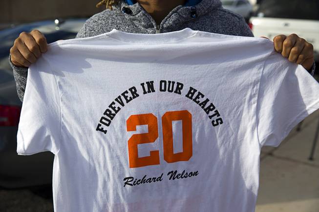 Malachi Miles, a former Chaparral High School football player and a close friend of former Chaparral athlete Richard Nelson, holds a T-shirt following a memorial service for Nelson at the school Thursday, Jan. 19, 2017. Money raised from T-shirt sales will be used for a scholarship in Nelson's name, organizers said.