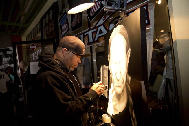 Airbrush artist Cliff works on a portrait of Willie Nelson during an event celebrating the collaboration between Willie's Reserve and Redwood Cultivation at Exhile in downtown Las Vegas, Tuesday Jan. 31, 2017.