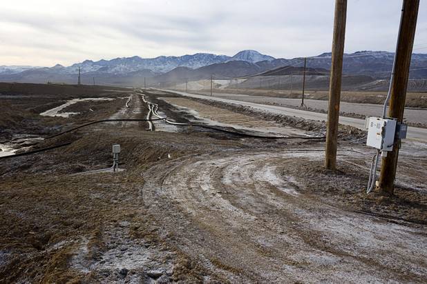 Silver Peak Road, right, a public roadway, cuts through a valley floor where the Silver Peak lithium mine has its evaporation ponds near Tonopah, Nev. Monday, Jan. 30, 2017.