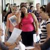 In this Tuesday, July 19, 2016, file photo, Reina Borges, left, stands in line to apply for a job with Aldi at a job fair in Miami Lakes, Fla.