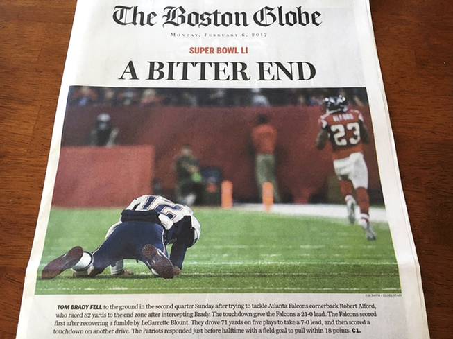 This Monday, Feb. 6, 2017, photo provided by Mary Tivnan shows a front page of an early edition of The Boston Globe in North Fort Myers, Fla. The front page of some early editions of New England's largest newspaper ran the headline, "A Bitter End" over an image of fallen New England Patriots quarterback Tom Brady, suggesting the Patriots lost to the Atlanta Falcons in Super Bowl 51.