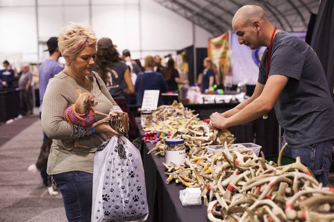 A pet owner buys some bone treats from the O'Fallon Antler Company the annual Pet Expo at the World Market Pavilion, Saturday, Feb. 11, 2017.