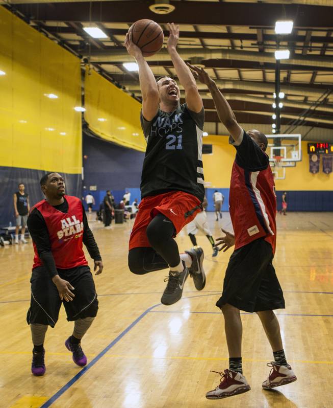 WALK Church player Alex Perez (21) jumps past Liberty players for a basket during a recreational league at the Tarkanian Basketball Academy on Friday, Feb. 10, 2017.  Ratner graduated Silverado High School as Nevada's all-time leading scorer for basketball and uses basketball to attract folks to his ministry.