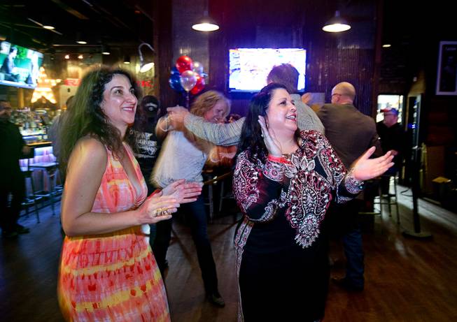 Women applaud a performance by the Tony Marques Band during the grand opening of John Rich's Redneck Riviera, a country bar in the Grand Bazaar Shops in front of Bally's, Thursday, Feb. 16, 2017. .