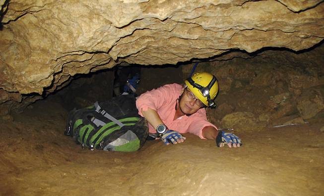 In this July 3, 2008, file photo, New Mexico Tech professor Penny Boston crawls through the Mud Turtle Passage on the way to the Snowy River formation during an expedition in Fort Stanton Cave, N.M. Boston, who discovered extreme life in New Mexico caves in 2008, presented new findings on Friday, Feb. 17, 2017, of microbes trapped in crystals in Mexico that could be 50,000 years old.