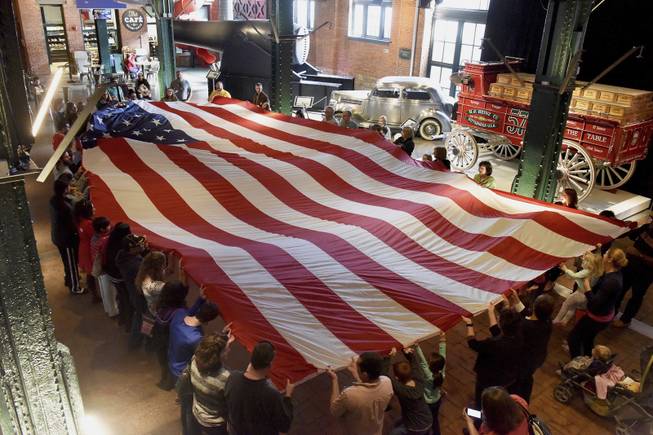 The 36-foot long American Flag is unfolded to start the Ceremony in the Sen. John Heinz History Center's Great Hall to celebrate "Presidents Day" in the Strip District section of Pittsburgh on Monday, Feb. 20, 2017. The Flag weighs 30 pounds. (Darrell Sapp/Pittsburgh Post-Gazette via AP)