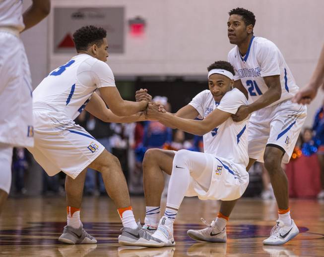 Bishop Gorman guard Ryan Kiley (23) helps lift up teammate Bishop Gorman guard Chuck O'Bannon (5) with Bishop Gorman guard Christian Popoola Jr (21) during their state 4A high school championship game at the Cox Pavilion on Friday, February 24, 2017.