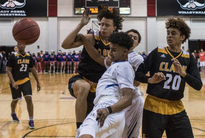 Clark guard Ian Alexander (32) and Bishop Gorman guard Jamal Bey (2) battle beneath the hoop during their state 4A high school championship game at the Cox Pavilion on Friday, February 24, 2017.