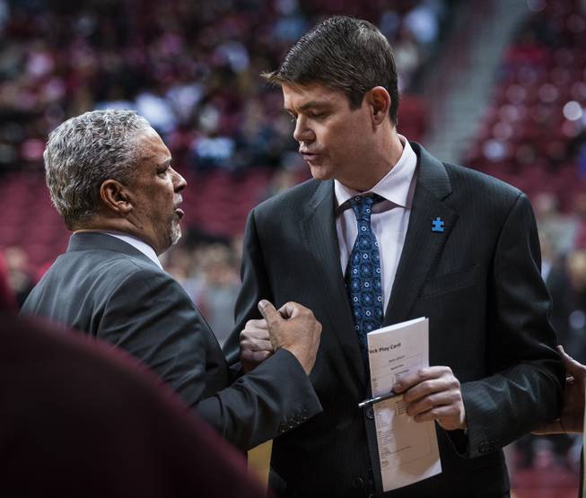 UNLV head coach Marvin Menzies chats momentarily with former coach and current UNR assistant coach Dave Rice on the sidelines at their game at the Thomas & Mack Center on Saturday, February 25, 2017.