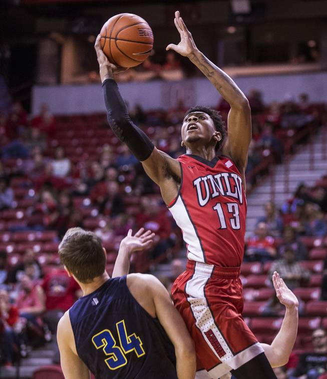 UNLV forward Ben Coupet Jr. (13) posts up for a shot over UNR forward John Carlson (34) during their game at the Thomas & Mack Center on Saturday, February 25, 2017.