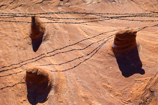 Barbed wire from a fence casts shadows on the rocks at Little Finland in Gold Butte National Monument Thursday, Feb. 23, 2017.