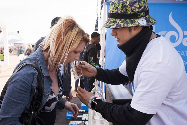 A festival goer tests out a smoking product at the Dr. Dabber booth with the help of a representative during the High Times U.S. Cannabis Cup in Moapa Valley, NV, Saturday, March 4, 2017.