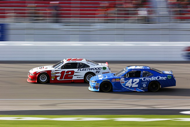 Joey Logano, left, races with Kyle Larson during the Boyd ...