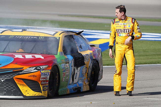 Kyle Busch walks away from his car in the pit ...