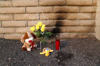 A makeshift shrine is shown against the rear wall of a northwest apartment complex Tuesday, March 14, 2017. Police are seeking the public's help after a teen's burned body was found at the complex Saturday.
