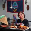 Carmen Taitague Tenorio displays her restaurant’s Fiesta Plate and Chamorro beignets.