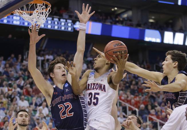 Arizona guard Allonzo Trier (35) goes to the basket as Saint Mary's Dane Pineau (22) and Evan Fitzner, right, defend during the first half of a second-round college basketball game in the men's NCAA Tournament, Saturday, March 18, 2017, in Salt Lake City.