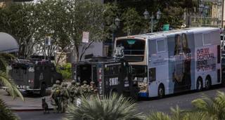 SWAT officers stage as they surround a suspect barricaded on a bus after a fatal shooting in the vehicle earlier today along the Strip outside the Cosmopolitan Hotel on Saturday, March 25, 2017.