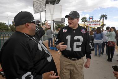 Raiders fans Robert Reyes, left, of Las Vegas, and Jeff Whitaker of Ithaca, Mich. chat by the Welcome to Las Vegas sign as NFL owners in Phoenix vote to approve a Raiders move to Las Vegas Monday, March 27, 2017.
