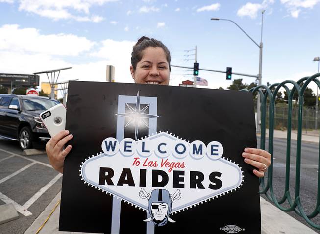 Raiders fan Brandee Chavez poses with a sign by the Welcome to Las Vegas sign after NFL owners in Phoenix voted to approve a Raiders move to Las Vegas Monday, March 27, 2017.