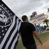 Matt Gutierrez carries a Raiders flag by the sign welcoming visitors to Las Vegas, Monday, March 27, 2017. NFL team owners approved the move of the Raiders to Las Vegas in a vote at an NFL football annual meeting in Phoenix. 