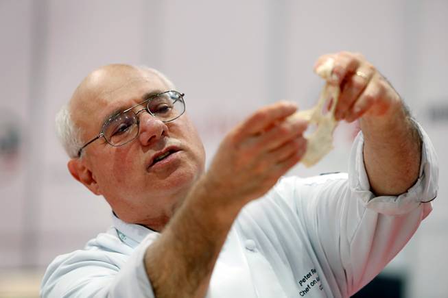 Baker and author Peter Reinhart holds up dough as he gives a bread-making demonstration during the International Pizza Expo at the Las Vegas Convention Center Tuesday, March 28, 2017.