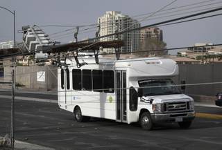 A downed power line rests on a bus along a road, Thursday, March 30, 2017, in Las Vegas. High winds are being blamed for multiple scattered power outages affecting almost 40,000 NV Energy customers in the Las Vegas area.