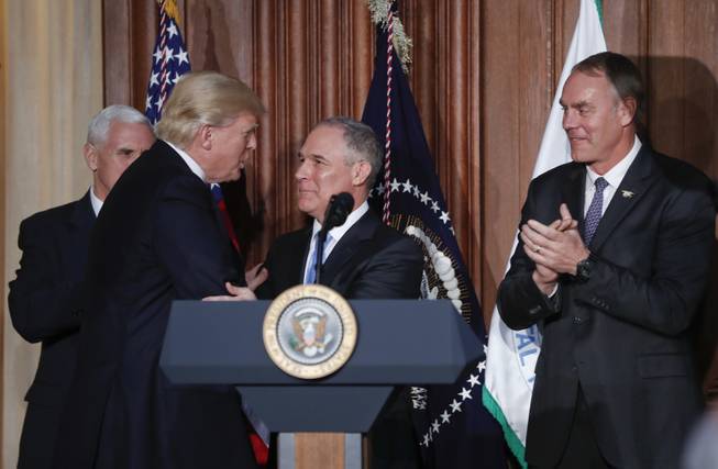 President Donald Trump shakes hands with Environmental Protection Agency Administrator Scott Pruitt, flanked by Vice President Mike Pence and Interior Secretary Ryan Zinke, before signing an Energy Independence Executive Order aimed at moving forward on his campaign pledge to unravel former President Barack Obama's plan to curb global warming.