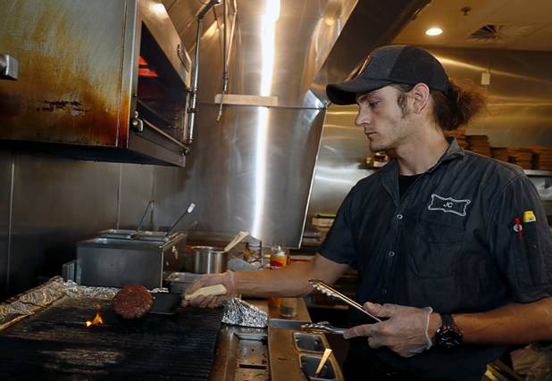 Chef Jeremy Chandler creates a White Truffle Bacon Aioli Burger at Public School 702 in Downtown Summerlin Monday, April 17, 2017. The bacon and cheese burger with a white truffle and cherry vinaigrette aioli is served on crispy onion straws. Paired with your choice of three beers, the burger and fries combo is $13.00 through April.