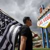 Matt Gutierrez carries a Raiders flag by the iconic sign welcoming visitors to Las Vegas in March, when the NFL approved the team's move. The Raiders will announce their NFL draft selections on Saturday during a party at the sign.