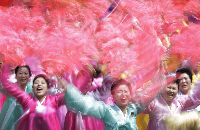 North Korean women wave and cheer as they look toward ...