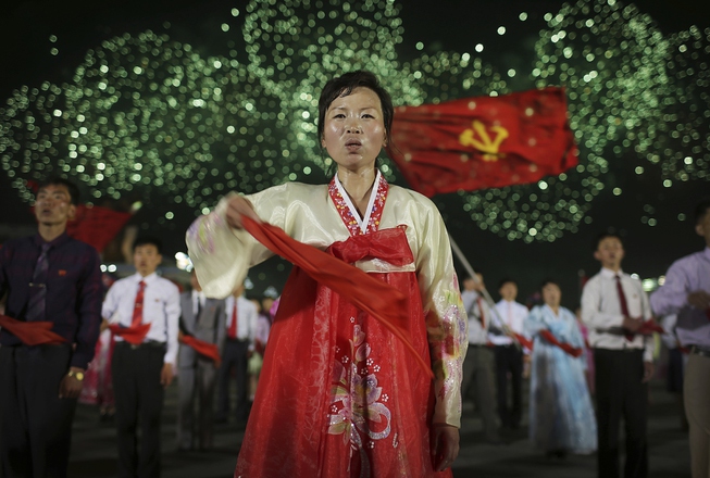 Fireworks explode while North Koreans participate in a mass dance ...